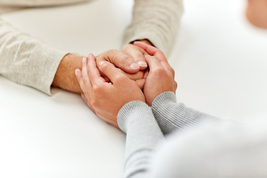 Close Up Of Old Man And Young Woman Holding Hands