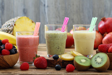 frappe' o frullato di frutta fresca tre bicchieri su sfondo rustico