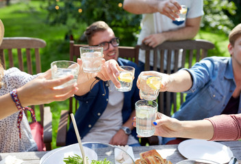 happy friends with drinks at summer garden party