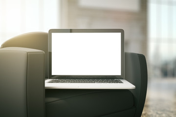 White laptop on black armchair