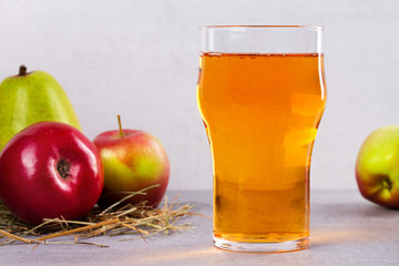 Glass and bottles of apple and pear cider with fruits