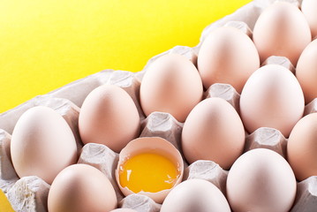 raw egg yolk in a box on a yellow background