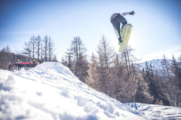 Naklejka na ściany i meble Snoboarder performing tricks on the snow