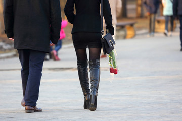 Obraz premium woman with flowers tulips in his hand, walking next to the man.