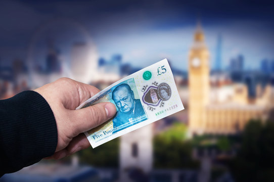 Money English five pound note in a man's hand concept.