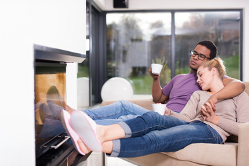 Fototapeta premium Young multiethnic couple in front of fireplace
