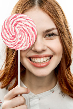 Brunette woman with big lollipop in hand