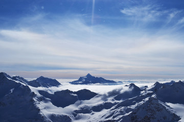 Fototapeta na wymiar snow peaks, ridge, blue sky, floating clouds. beautiful view from ski slope.