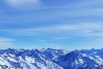 Fototapeta na wymiar snow peaks, ridge, blue sky, floating clouds. beautiful view from ski slope.