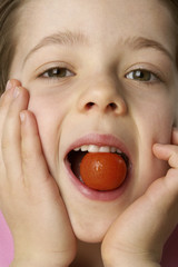 Boy eating a tomato