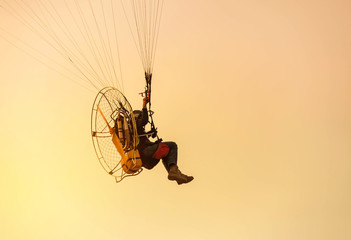 paraglider flying  with paramotor on sunset