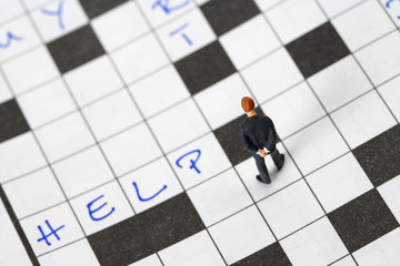 Businessman figurine on a crossword puzzle