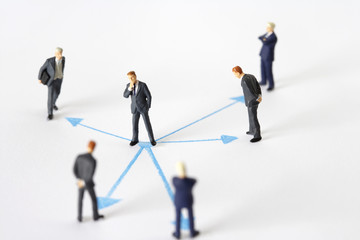 Fototapeta premium Businessmen figurines and arrows