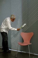 Senior man cleaning the wall with a small broom