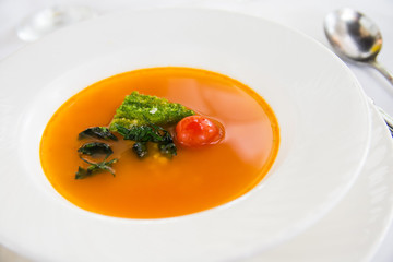 fresh tomato soup with bread dipped in pesto