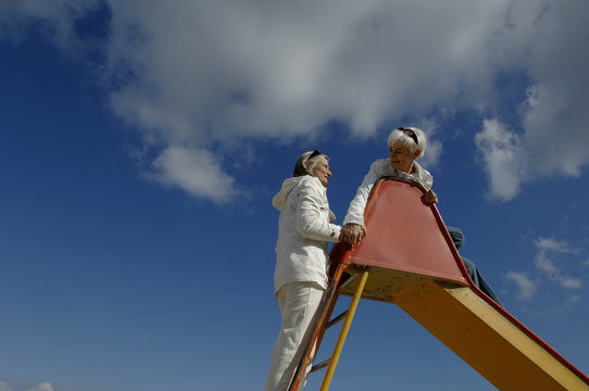 Two mature women at a slide