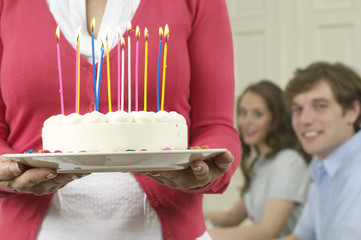 Woman carrying a birthday cake