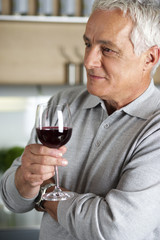 Gray-haired man with a glass of wine in his hand, close-up