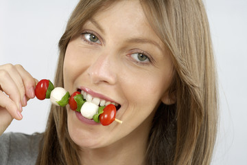 Mid adult woman eating vegetable kebab