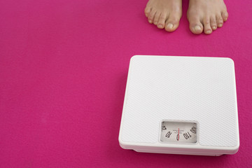 Woman standing next to a weighing scale