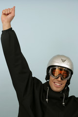 A man wearing ski goggles and a safety helmet and cheering