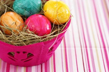 Nest made of straw with eggs in a basket, close-up