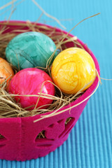 Nest made of straw with eggs in a basket, close-up