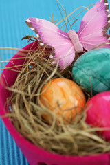 Nest made of straw with eggs in a basket, close-up
