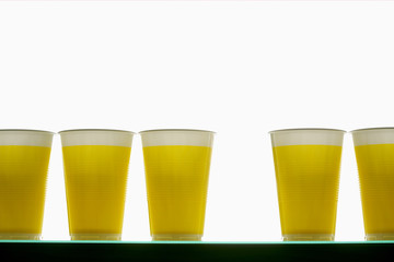 Yellow plastic cups in a row