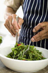 Mature man preparing salad