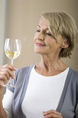 Senior woman holding a glass of white wine