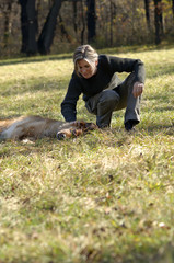 Woman plays with lying dog