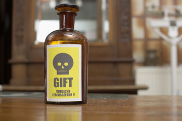 A brown glass bottle with poison sign