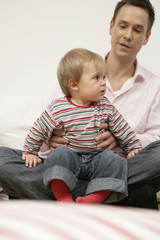 Son sitting on father's lap