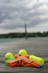 Two water pistols lying on a wooden footbridge, selective focus