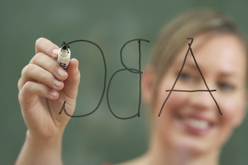 Woman is writing on an glass board