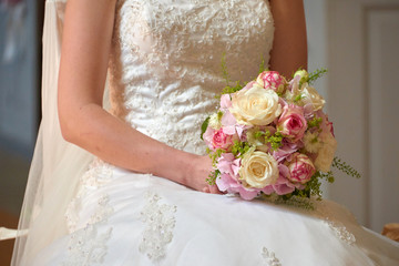 bride holding wedding bouquet with roses