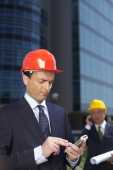 Businessman with hardhat using a mobile phone