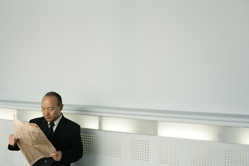 Asian businessman reading a newspaper