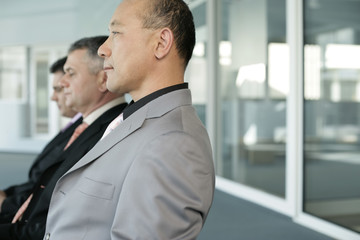 Three businessmen sitting in a row