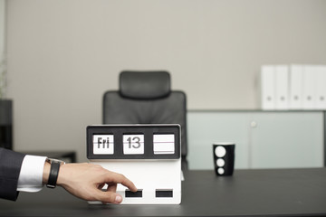Businessman pointing on calendar showing Friday 13