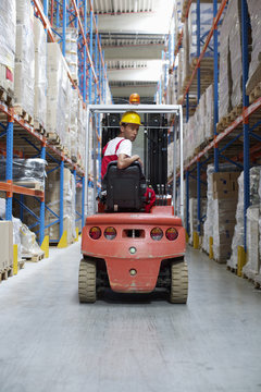 Young man sitting on a fork lift