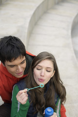 Young couple blowing soap bubbles