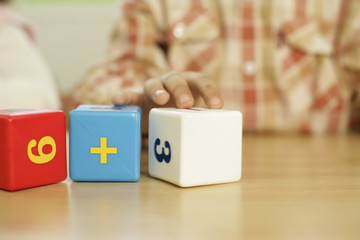 Child playing with building blocks with numbers