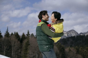 Fototapeta premium Young man carrying laughing woman