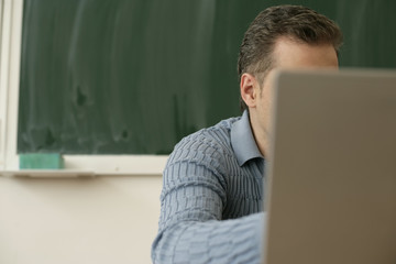 Teacher sitting behind a laptop
