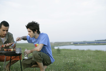 Fototapeta premium Two young men grilling