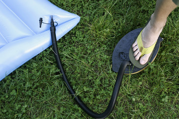 Man pumping up a blue airbed