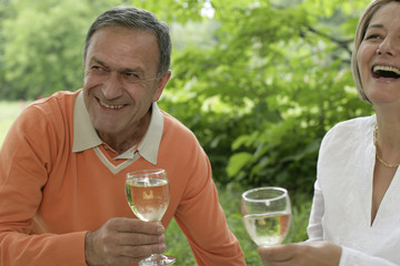 Laughing mature couple drinking white wine
