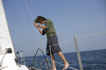 Man balancing at sailboat border